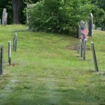 A side view of two headstone rows going up a small hill